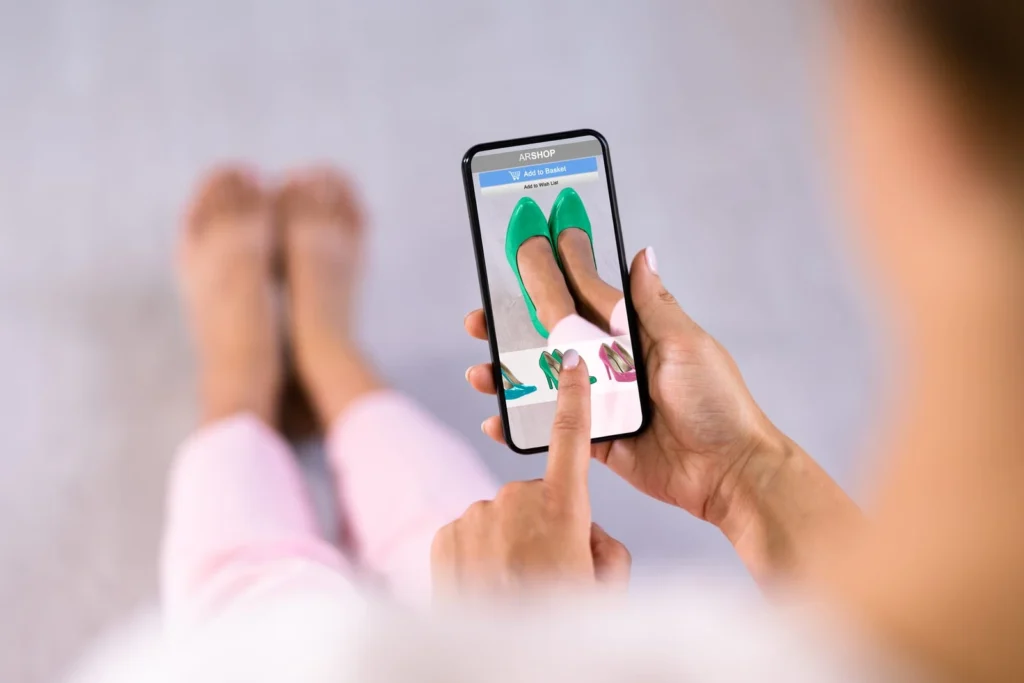 Woman trying on virtual high heels using AR shopping app on smartphone