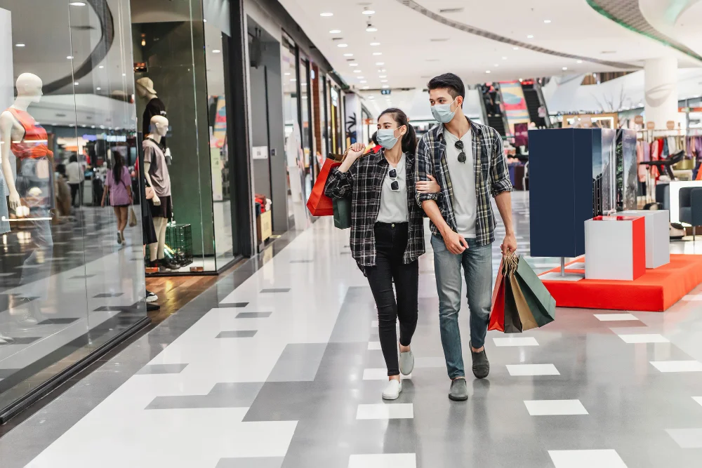 Where does Gen Z shop in China? Young shoppers walking through a modern shopping mall carrying bags, representing online-influenced offline retail behavior