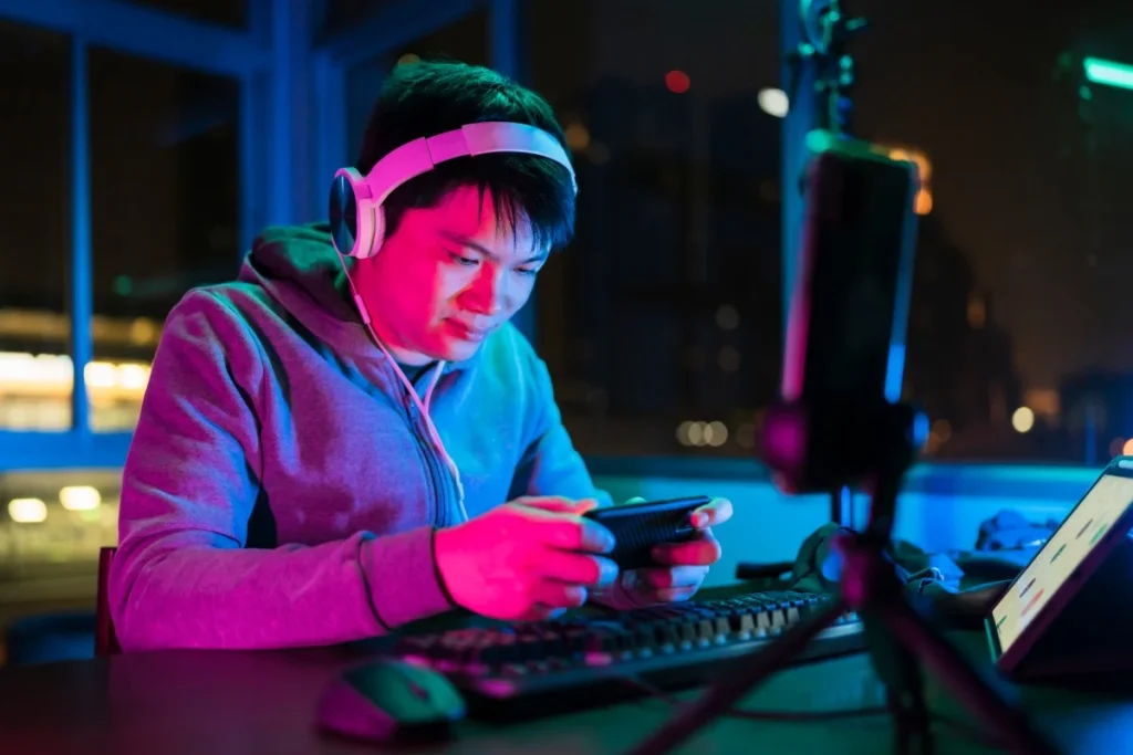gamer playing mobile game with friends at night