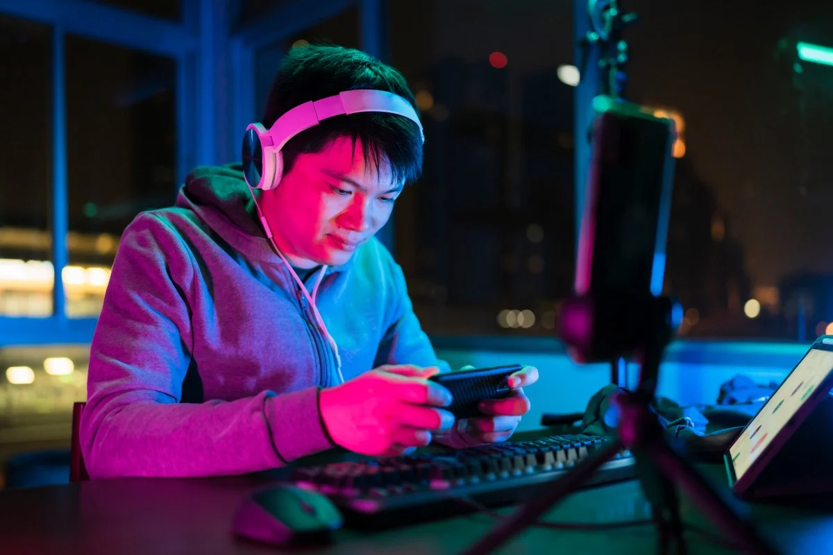 gamer playing mobile game with friends at night