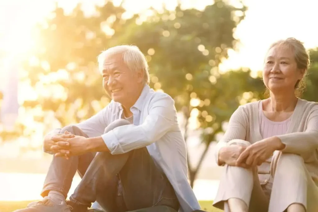 Senior Chinese couple sitting outdoors in a relaxed setting after a thoughtful conversation