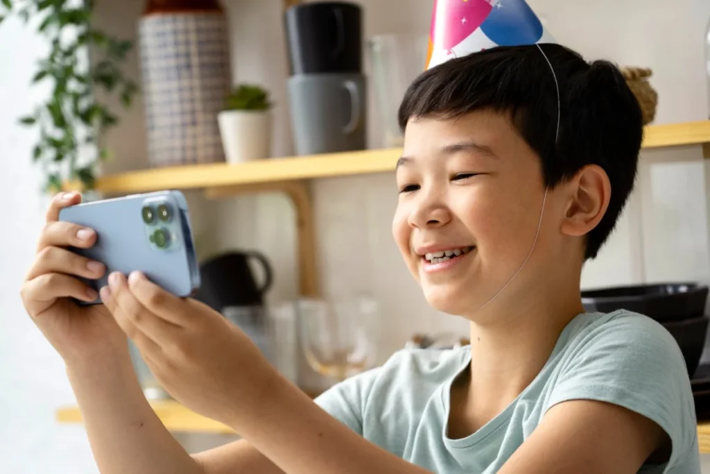 Smiling child using smartphone enjoying playful mobile app experience indoors