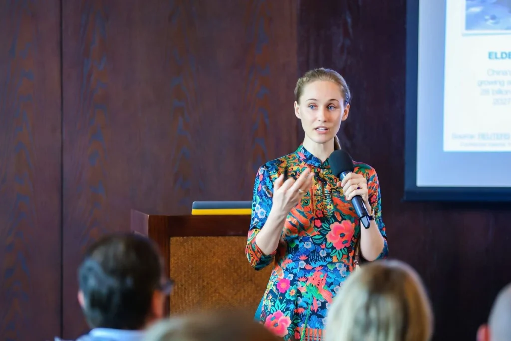 Ashley Dudarenok speaking on stage during a presentation to an audience about consumer trends in China