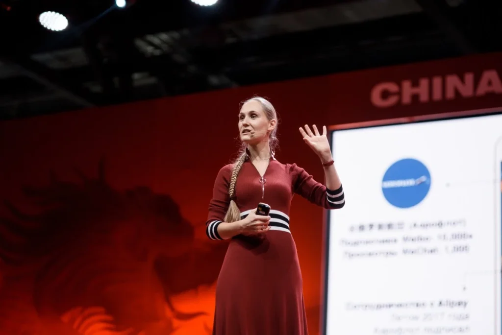 Speaker presenting insights on Chinese consumer trends and emotional spending at a live event.