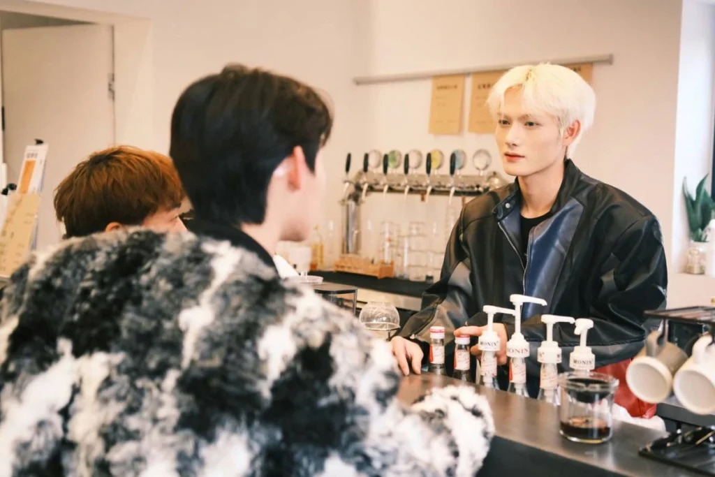 Two people at a modern tasting counter with bottled products displayed on the bar