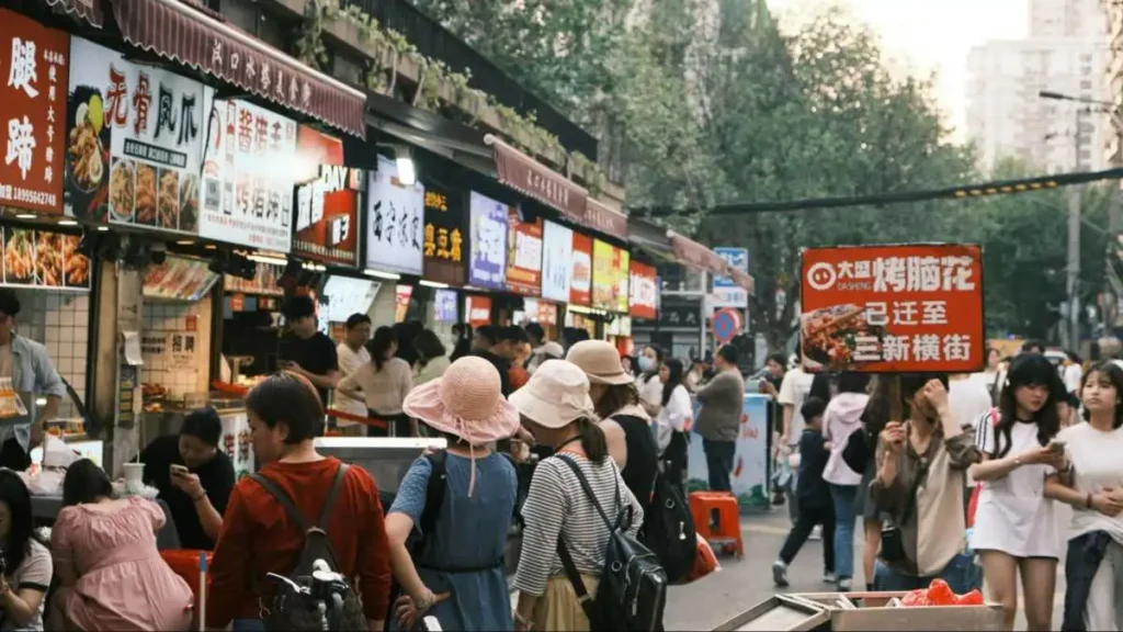 Crowded retail and food street in China illustrating routine spending under closer scrutiny.