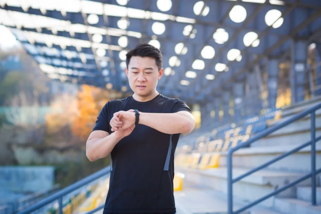 Man checking a fitness tracker during an outdoor workout