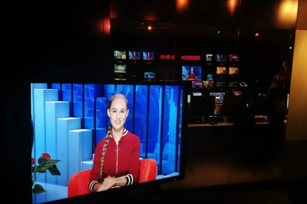 Television studio control room with presenter displayed on multiple screens