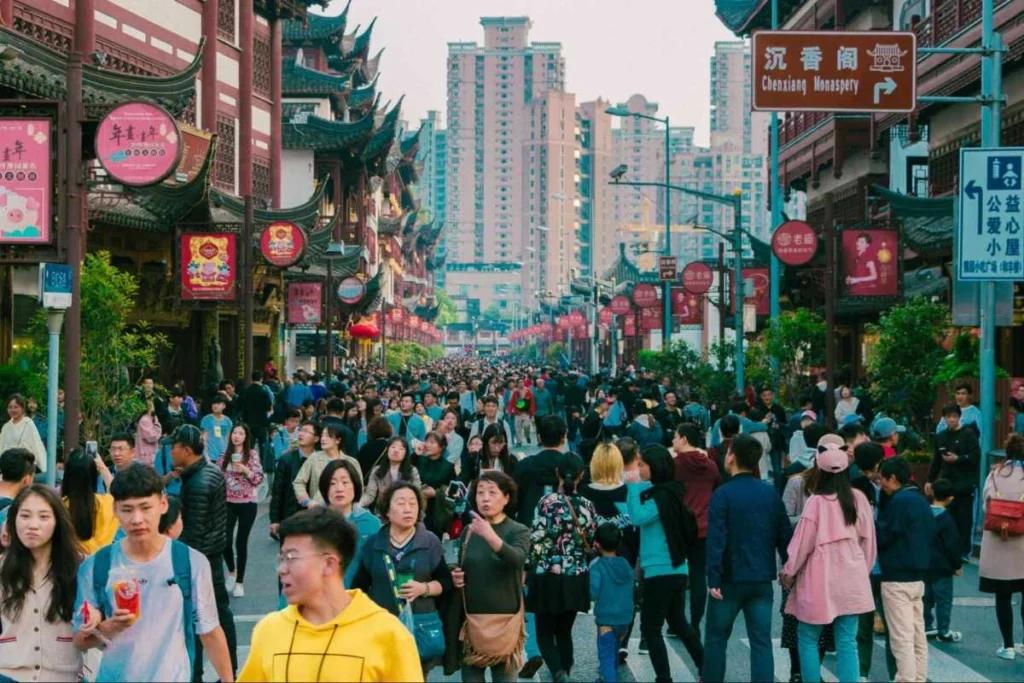 Crowded shopping street in China with consumers moving through a busy retail district