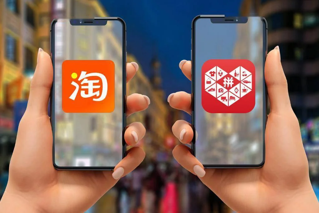 Hands holding two smartphones showing Taobao and Pinduoduo app logos against a blurred city street background