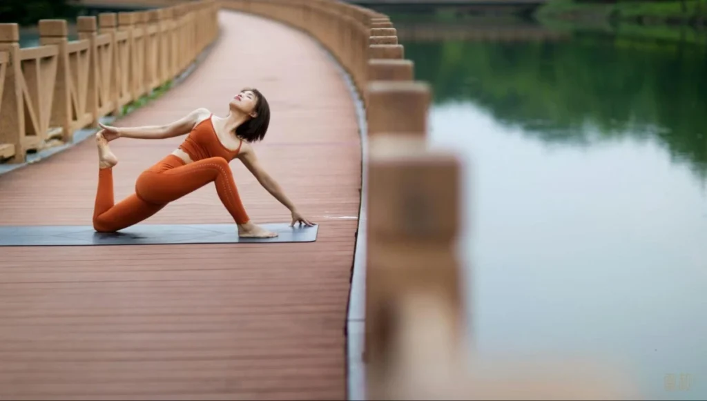 A woman stretches by the water, showing how healing experiences support calm and recovery.