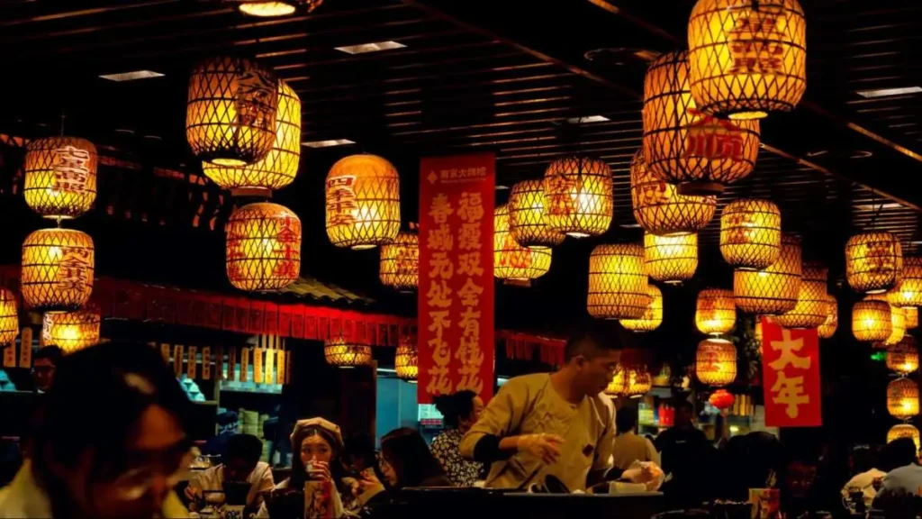 Diners gather under red lanterns in China, showing how social moments remain part of meaningful consumption.
