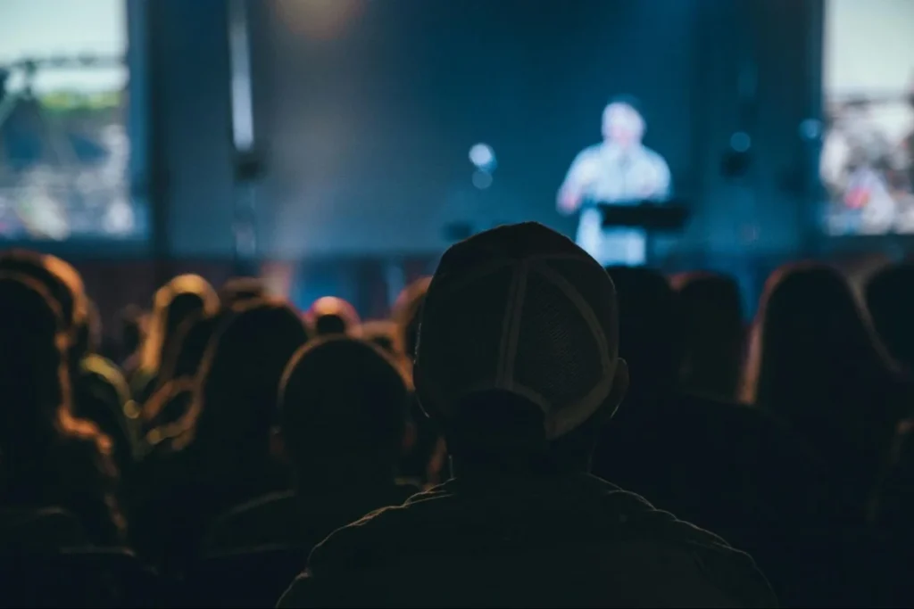 Business conference audience listening to a keynote speaker on stage