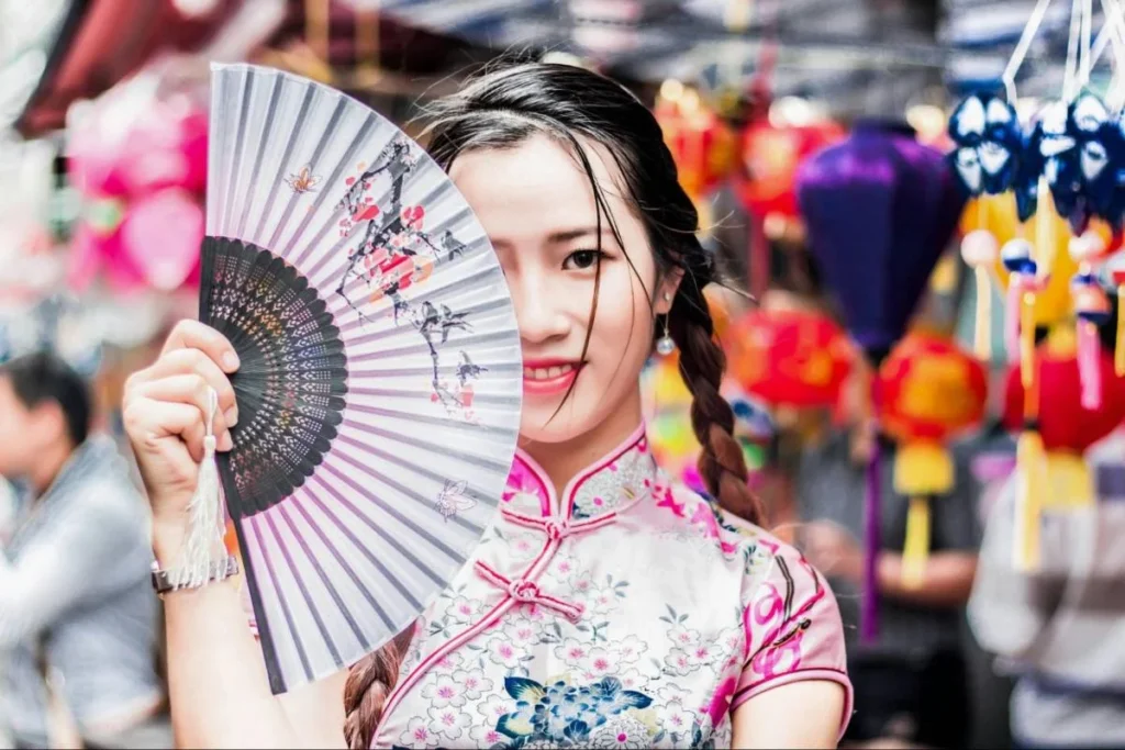 Shopper holding a traditional fan in a Chinese market, reflecting local context and consumer experience.