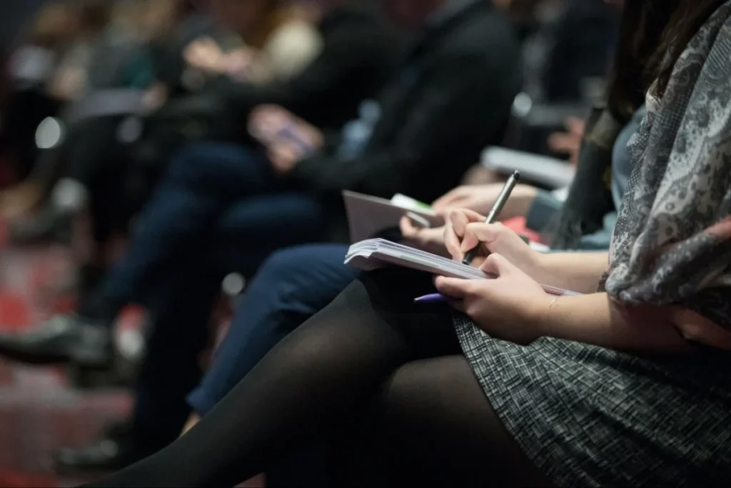 Executive audience taking notes during a business conference keynote session