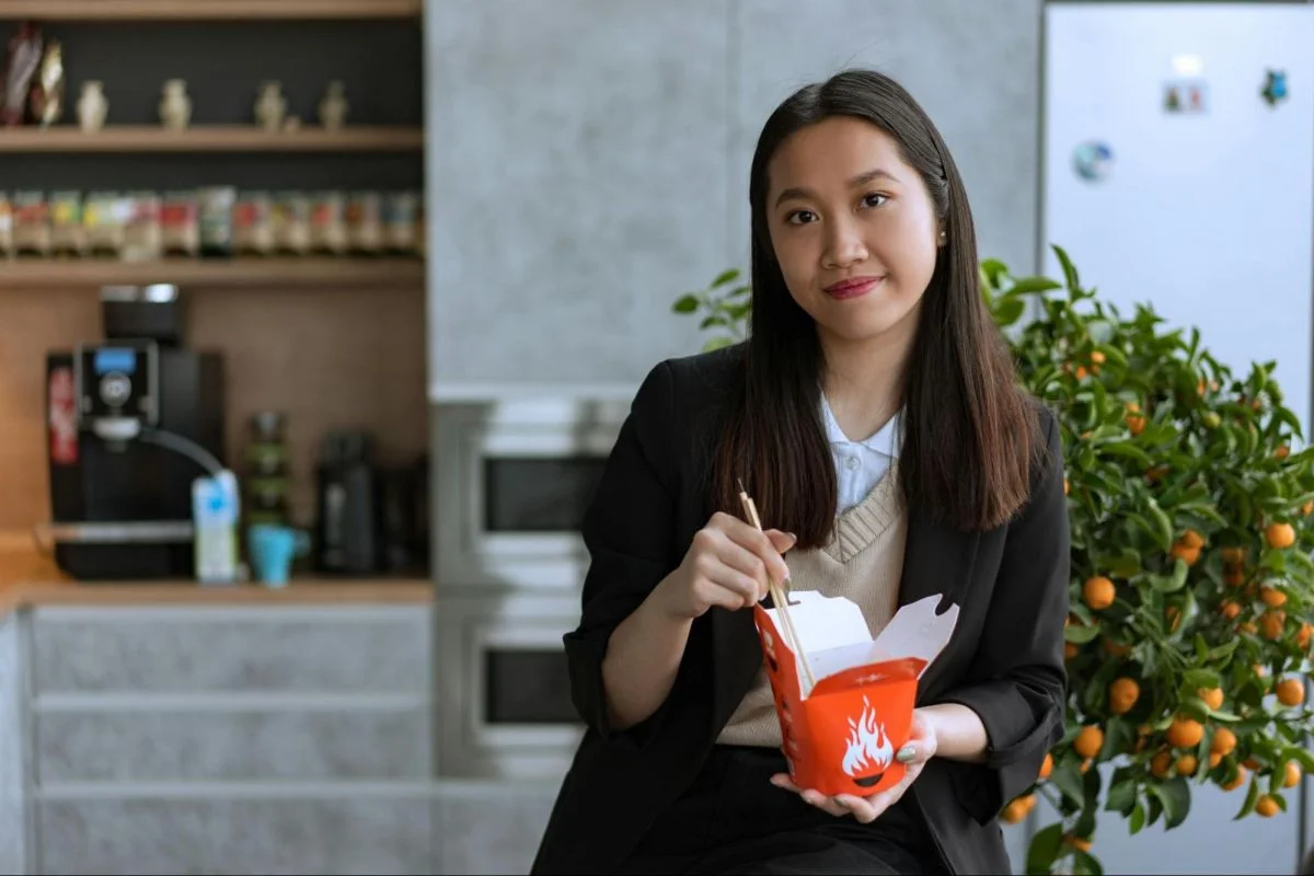 Woman eating alone in a modern setting, illustrating how living alone in China shapes solo consumer routines.