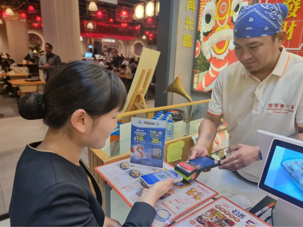 Customer paying with Alipay at a restaurant counter