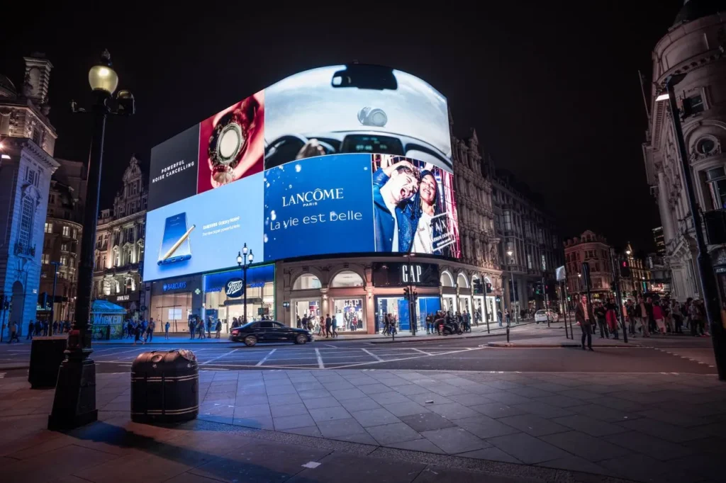 Large digital billboard display lighting up a city street at night