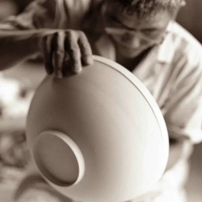 Artisan carefully shaping a large porcelain bowl by hand