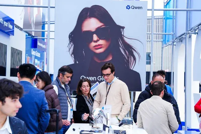 Visitors exploring a Qwen display booth at a technology exhibition