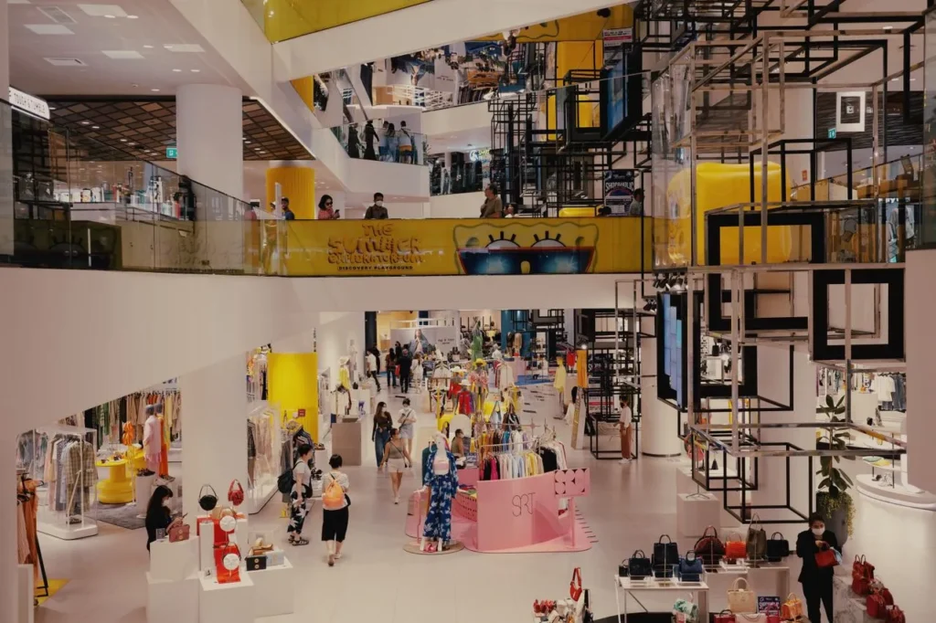 Bright shopping mall interior with fashion stores and shoppers