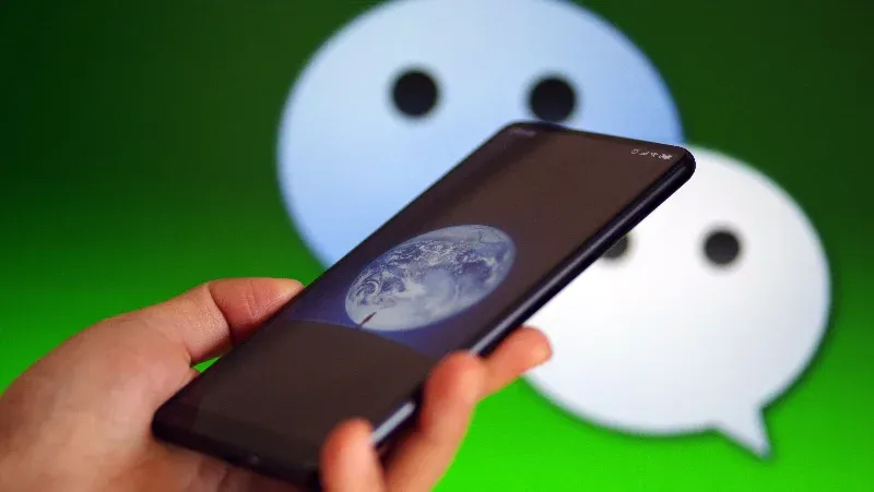 Smartphone held in front of the WeChat logo