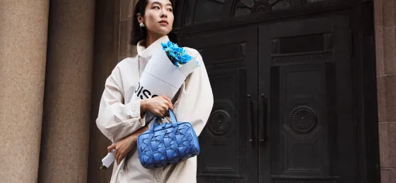 Woman carrying a blue DISSONA woven handbag