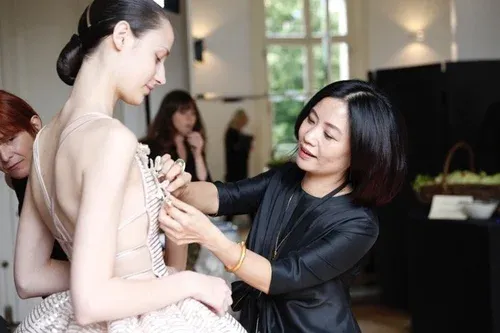 Designer fitting a couture dress on a model