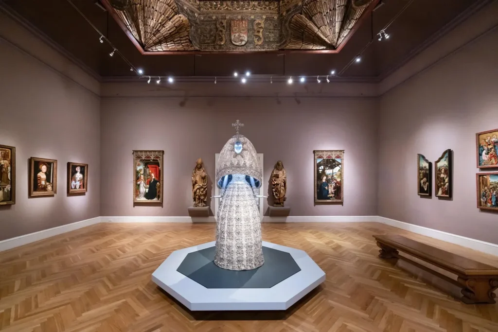 Silver couture gown displayed in a museum gallery