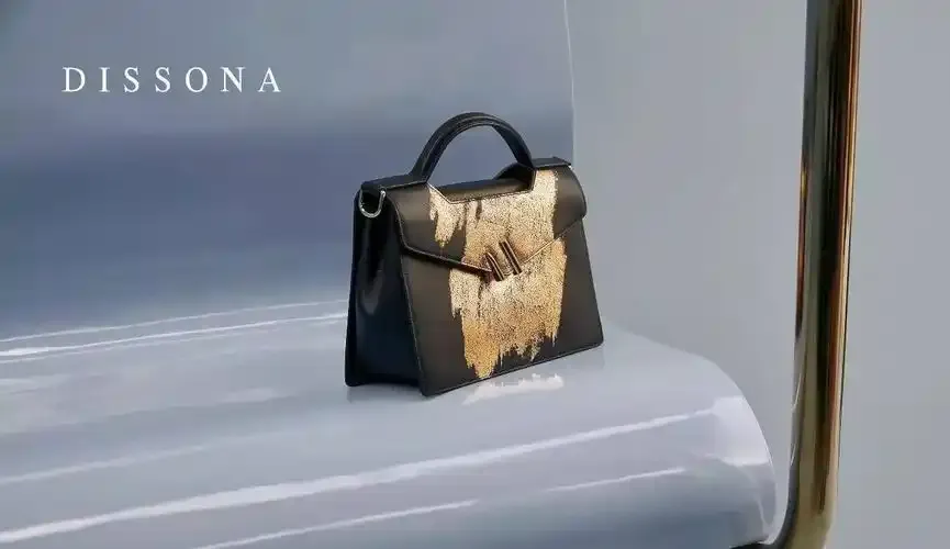 Black DISSONA handbag with gold textured front detail