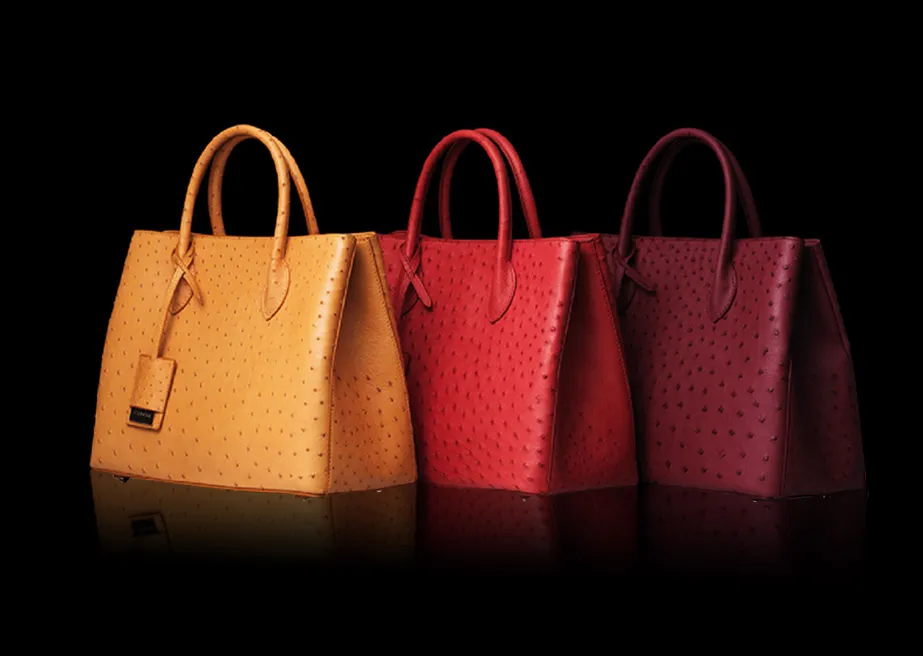 Three colorful DISSONA leather tote bags on black background
