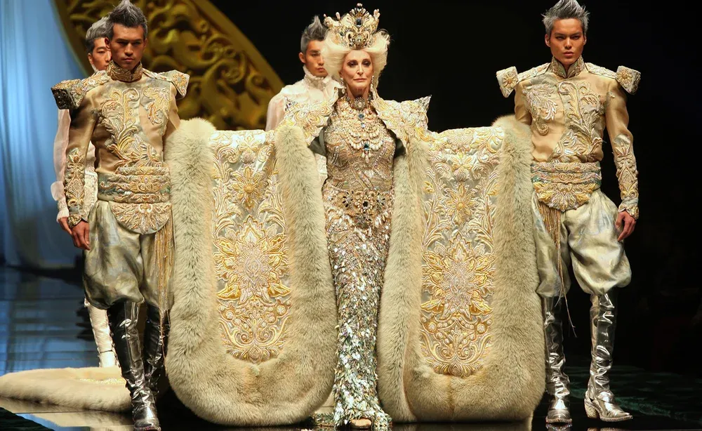 Models wearing ornate gold couture on a runway