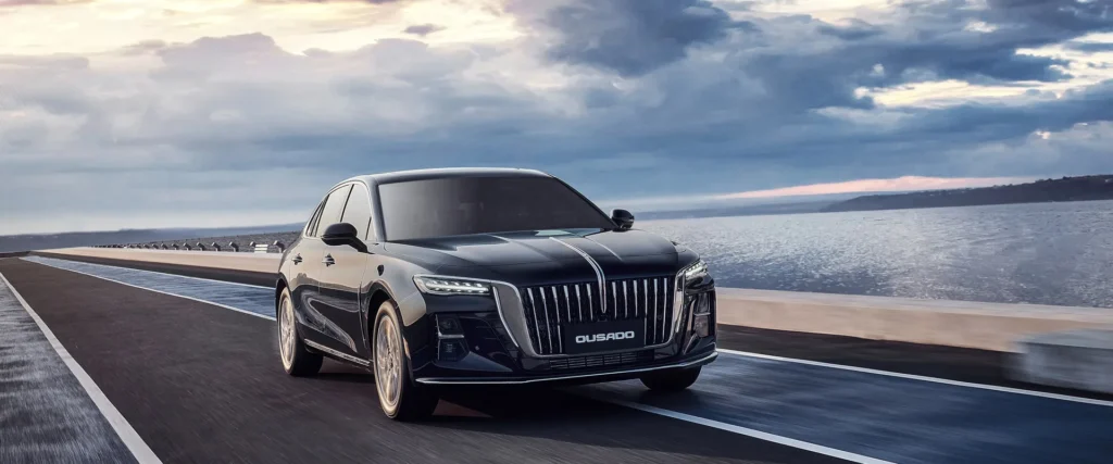 Black Hongqi luxury sedan driving on a coastal road