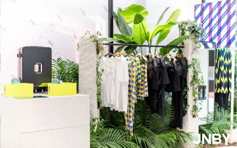 JNBY clothing display with plants and colorful garments