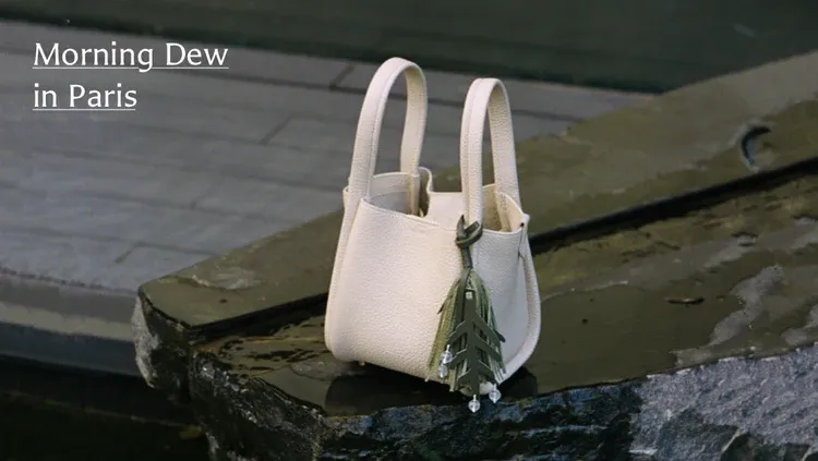 Cream Songmont bag displayed on a stone surface