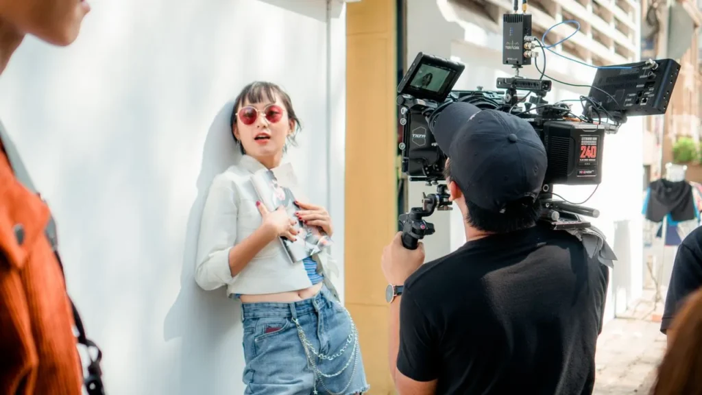 Camera crew filming an actress during an outdoor scene