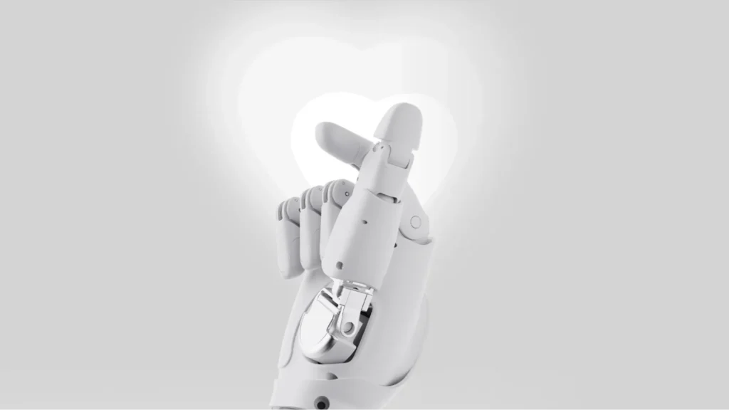 White robotic hand forming a heart gesture on a soft gray background