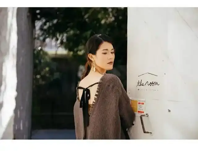 Model wearing textured Uma Wang knitwear outside a boutique