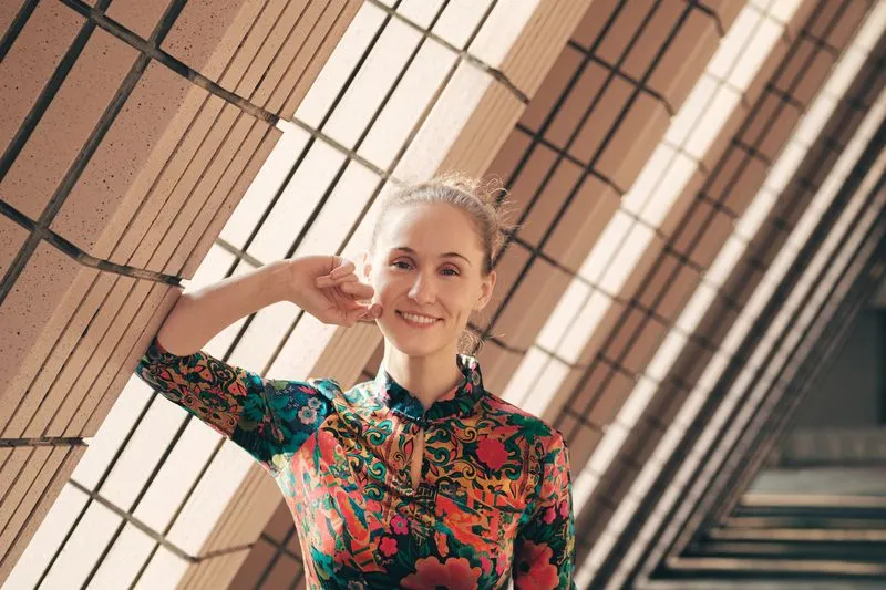 Woman standing near a building wall in a colorful outfit