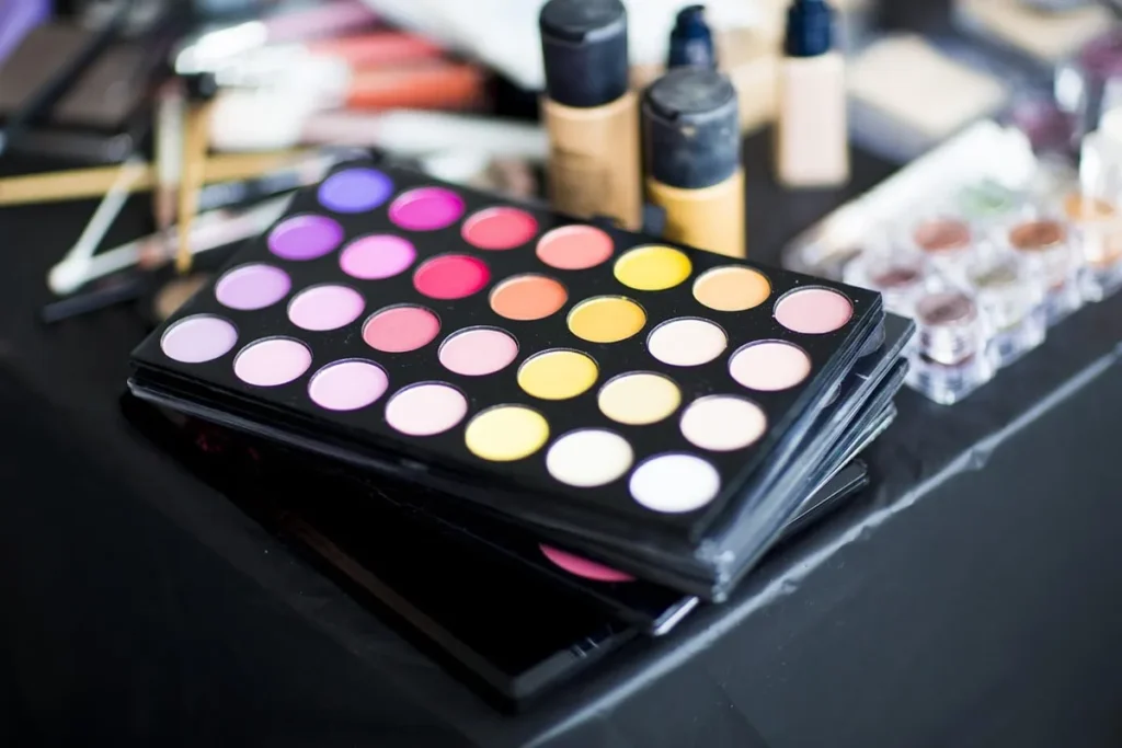 Colorful eyeshadow palette with makeup products on vanity
