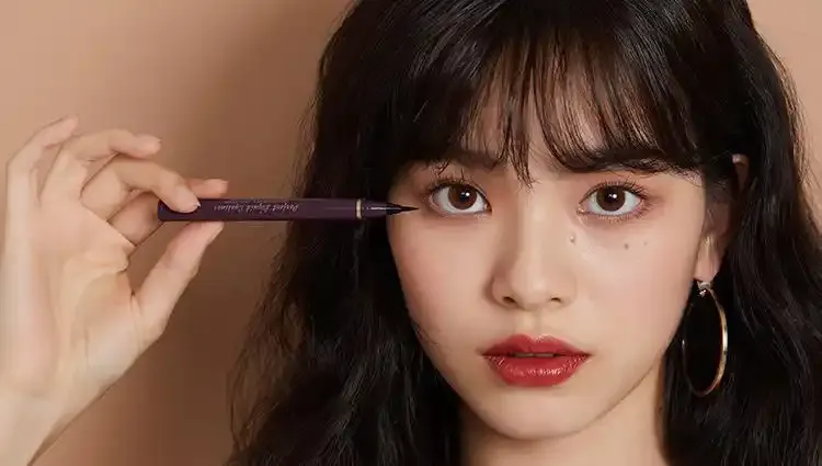 Model applying Judydoll eyeliner for a defined eye makeup look