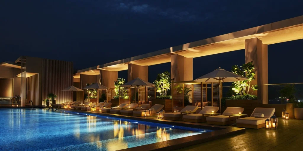 Luxury rooftop swimming pool illuminated at night