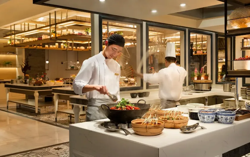 Chef preparing food in an open hotel kitchen