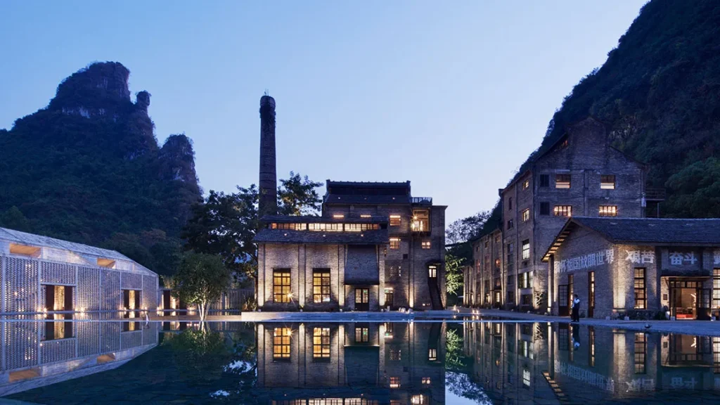 Restored industrial hotel surrounded by karst mountains